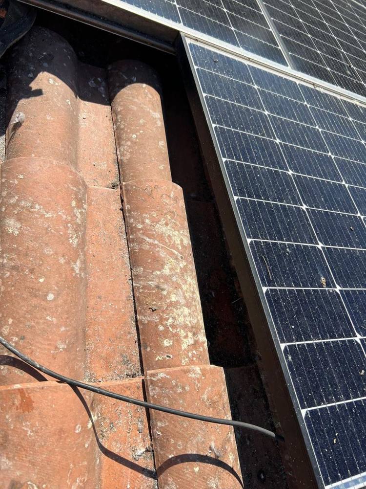Dettaglio pannello solare e tegole con muschio prima della manutenzione